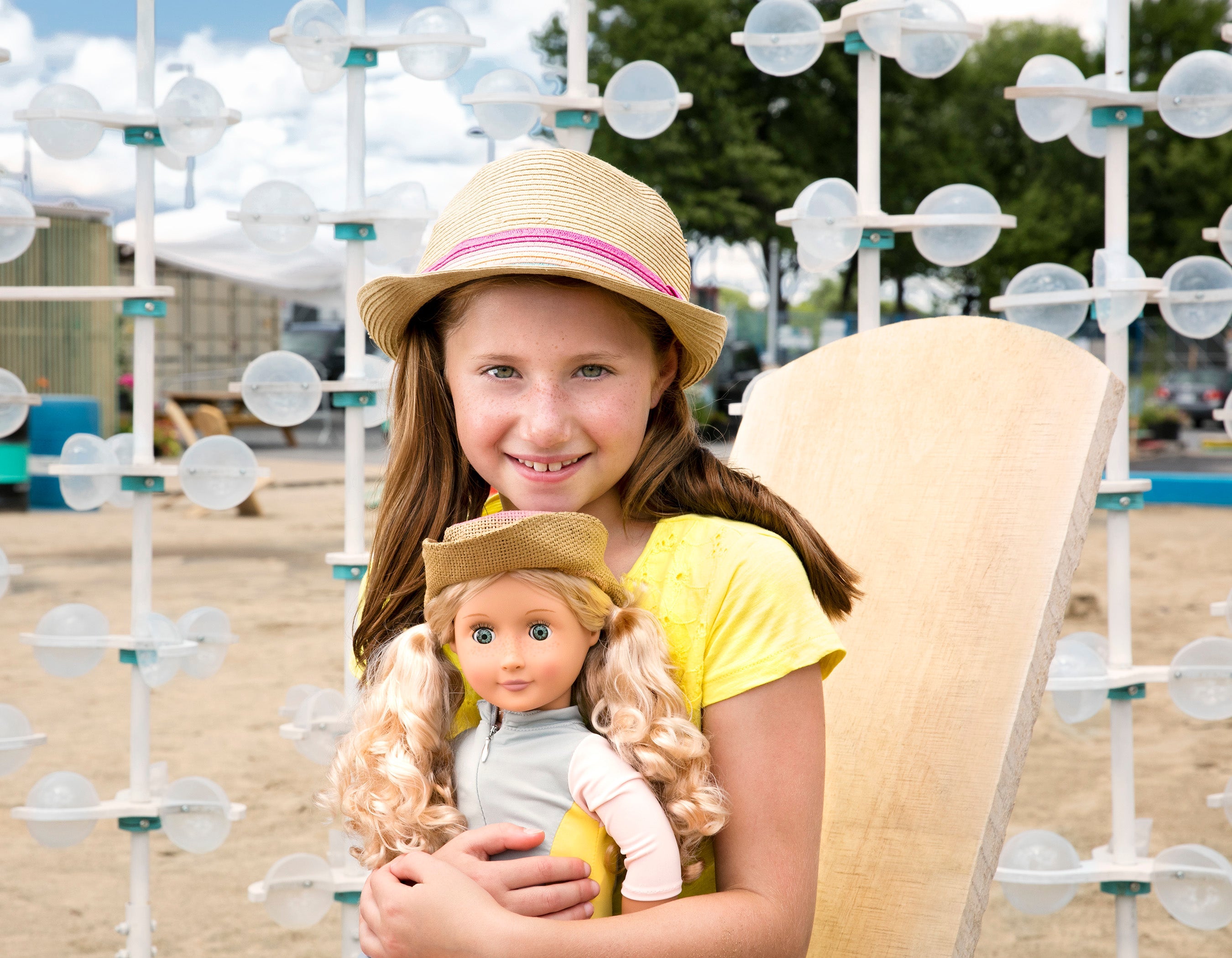 Little girl hugging doll on the beach